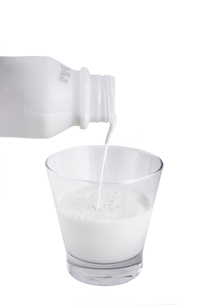 Pouring fresh milk into glass - Foto, afbeelding