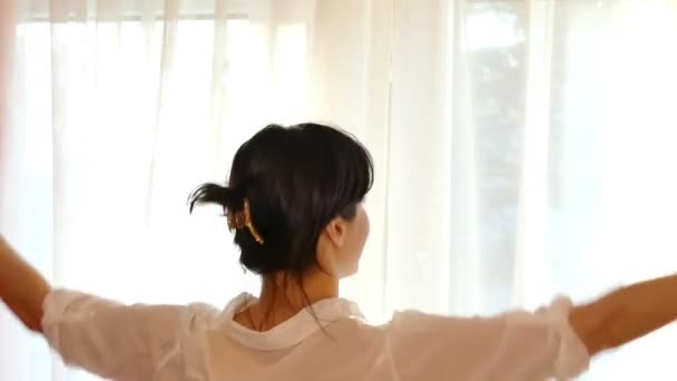 Aufwachen und Sonnenlicht-junge Frau breitet Vorhänge aus - Filmmaterial, Video