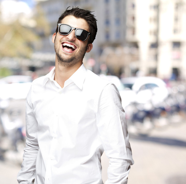 Ritratto di giovane uomo con occhiali da sole che ride di città
 - Foto, immagini