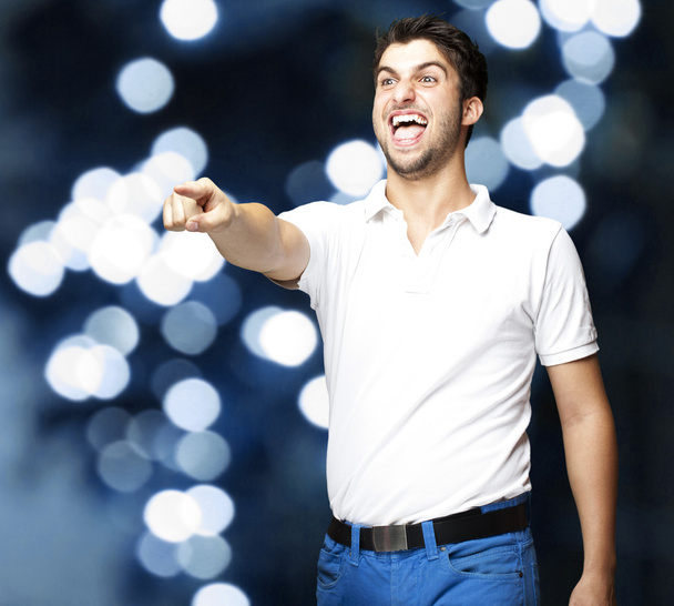 Retrato de un joven bromeando contra un fondo de luces azules
 - Foto, Imagen