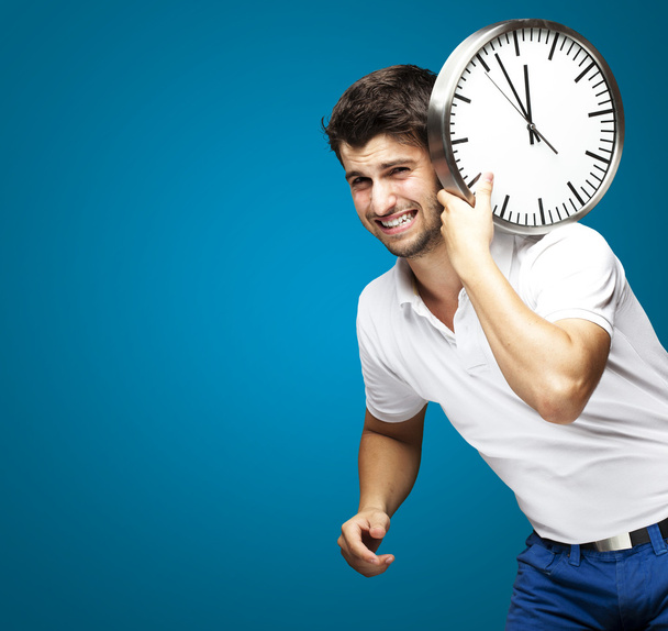 Retrato de un joven guapo llevando un reloj contra un azul
 - Foto, Imagen