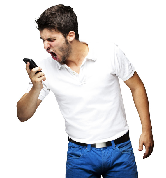 Πορτρέτο της φωνάζει θυμωμένος νεαρός που χρησιμοποιούν κινητό πάνω από το λευκό bac - Φωτογραφία, εικόνα