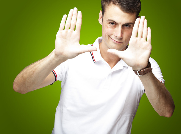 Portré, fiatal ember csinálás fotó gesztus, felső zöld háttér - Fotó, kép