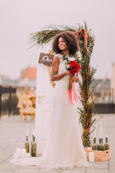 Charming black bride dreamily looks intj the sky on the terrace. Wedding day - Photo, Image