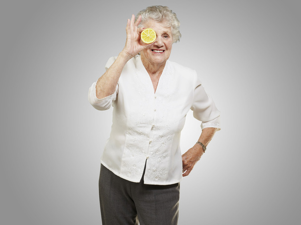portret senior kobiety z cytryny przed jej oko gey - Zdjęcie, obraz