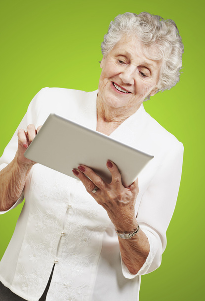 Porträt einer Seniorin mit digitalem Tablet auf grünem Rücken - Foto, Bild
