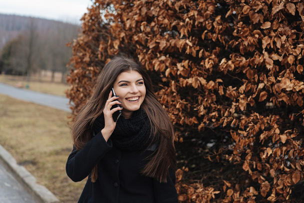 Beautiful girl with phone in park - Valokuva, kuva