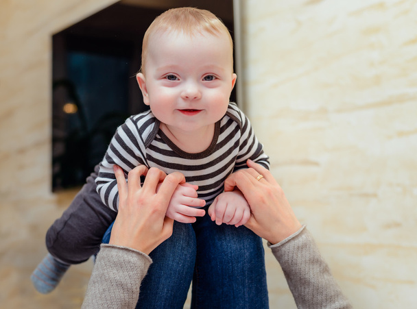 Giechelen baby omhoog op knieën voor volwassene - Foto, afbeelding