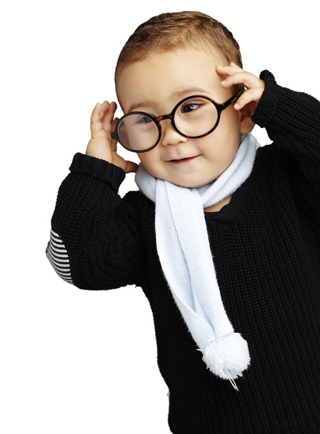 Retrato de un niño divertido sosteniendo sus gafas contra un respaldo blanco
 - Foto, imagen
