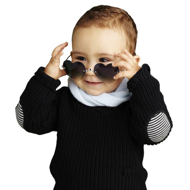 Portrait of funny kid wearing heart sunglasses against a white b - Foto, afbeelding