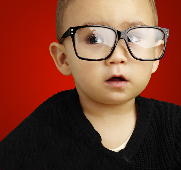 Portrait d'enfant portant des lunettes sur fond rouge
 - Photo, image