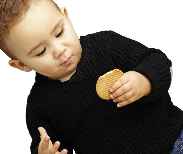Portrait of handsome kid eating a biscuit against a white backgr - Photo, Image