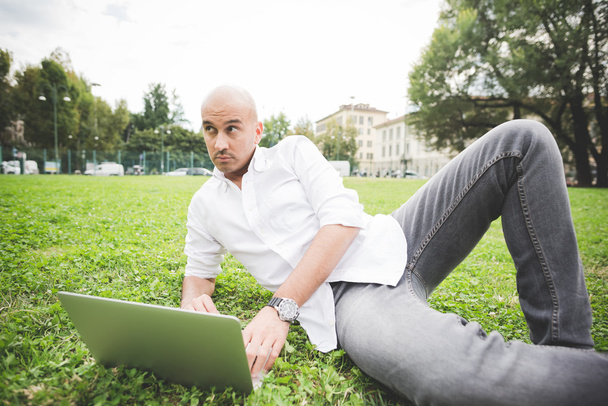 людина в міському парку використовує ноутбук
 - Фото, зображення