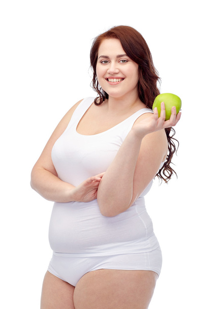 happy plus size woman in underwear with apple - 写真・画像