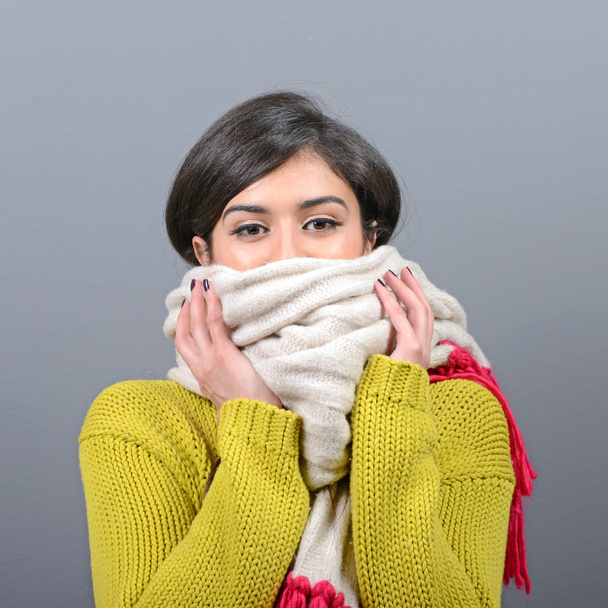 Портрет молодой женщины в зимней одежде против серой спинки
 - Фото, изображение