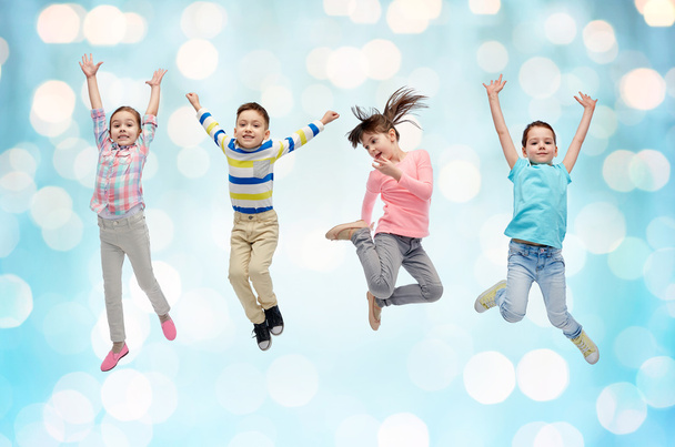 happy little children jumping over blue lights - Foto, Imagem