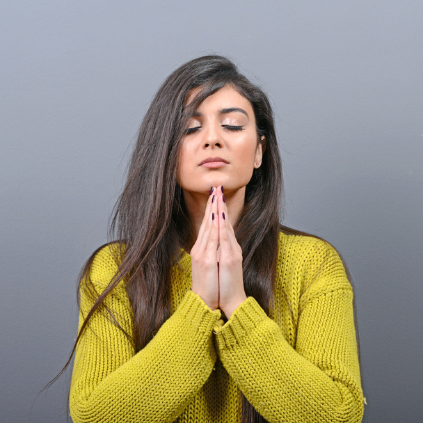 Woman praying about something or begging for mercy against gray  - Photo, Image