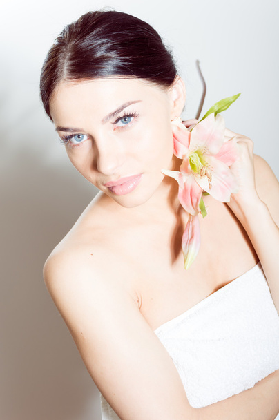 Beautiful lady with lilly flower. Perfect skin. - Фото, изображение