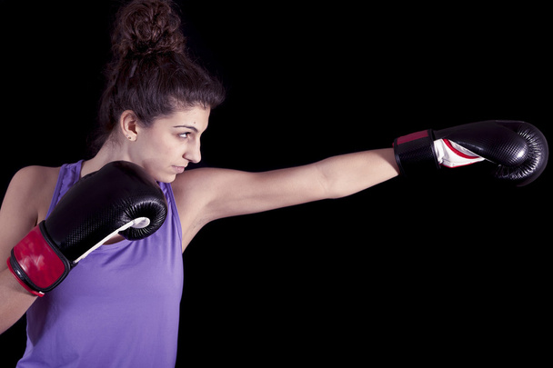 young female boxer hits during a workout - Photo, image