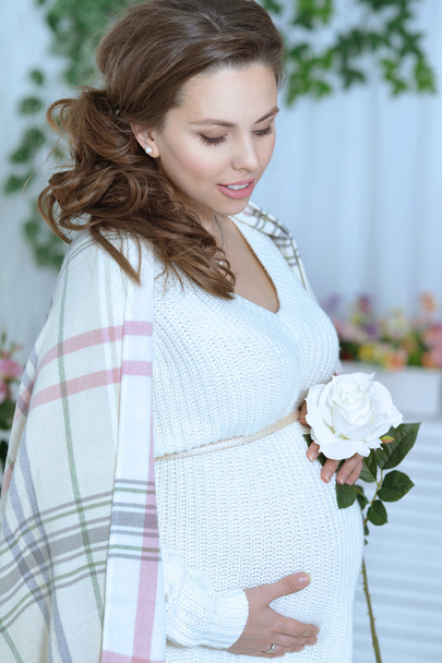 beautiful pregnant woman with white rose - Фото, изображение