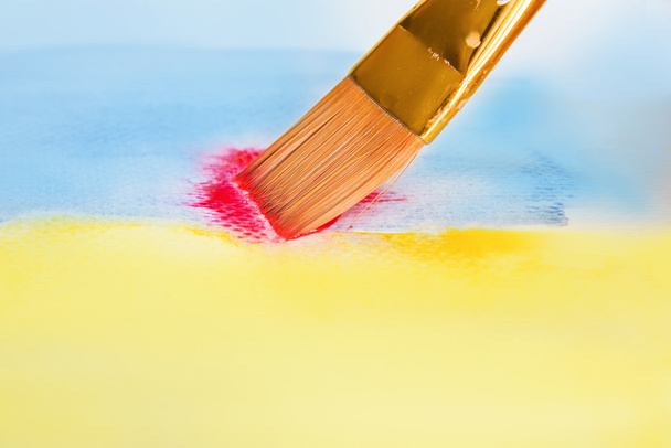 Brosse avec aquarelle de peinture bleue et jaune et rouge
 - Photo, image