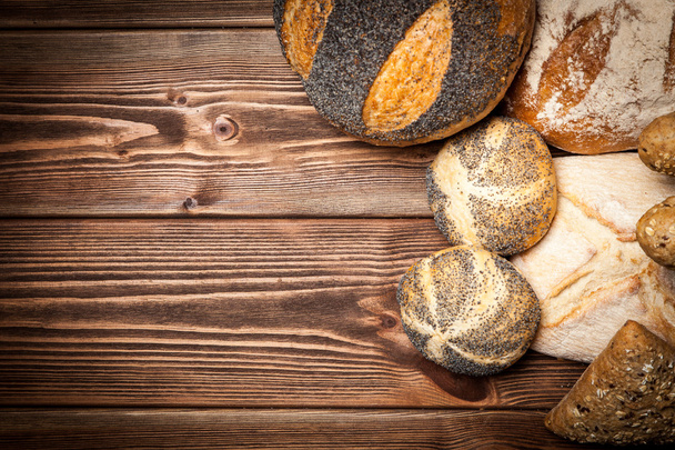 Bread assortment on wooden surface - Foto, afbeelding