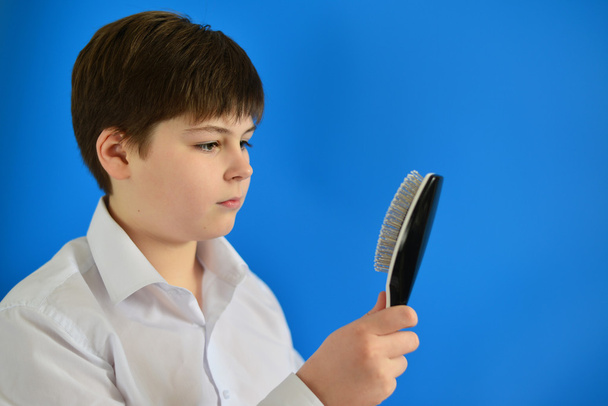 Boy teenager with comb in his hand - 写真・画像