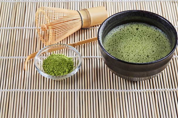 Green matcha tea preparation set on a bamboo table mat - Fotografie, Obrázek