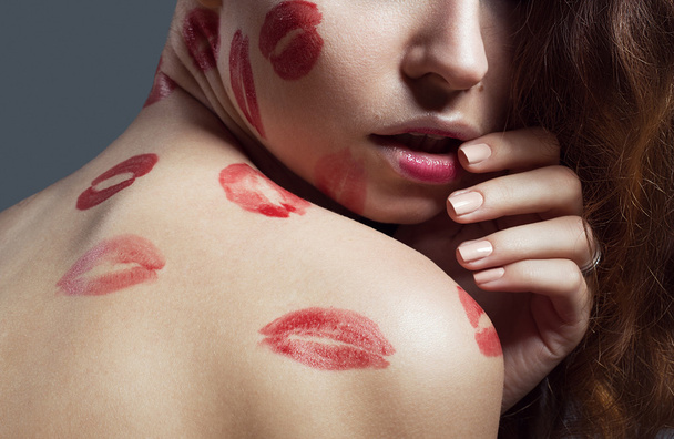 moda belleza mujer con besos. Los labios rojos. Piel perfecta. Fondo gris. Grabado en estudio. Modelo sexy
 - Foto, imagen