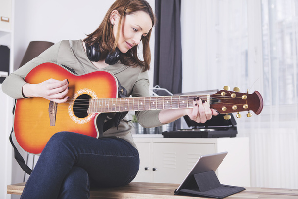Молодая красивая женщина любит музыку и играет на гитаре
 - Фото, изображение