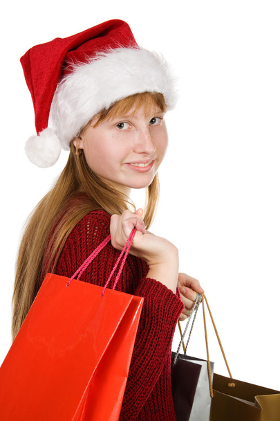 Teenager girl in christmas hat with shopping bags - Valokuva, kuva