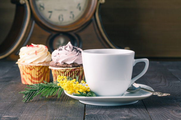 Closeup cup of tea and cupcakes on wooden table - Fotó, kép