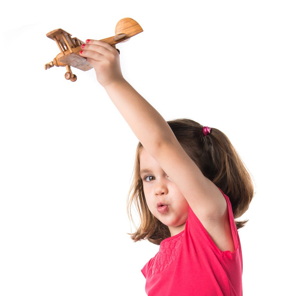 Девушка держит деревянный игрушечный самолет
 - Фото, изображение