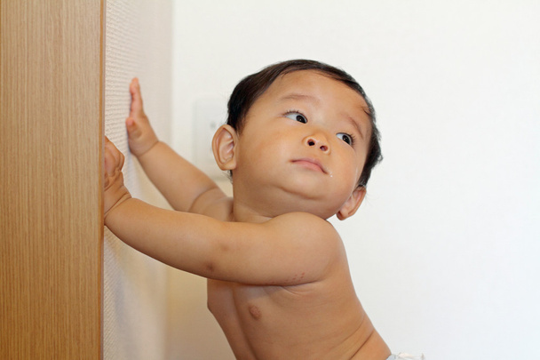 Japanse jongetje omhoog te trekken te staan (0 jaar oud) - Foto, afbeelding