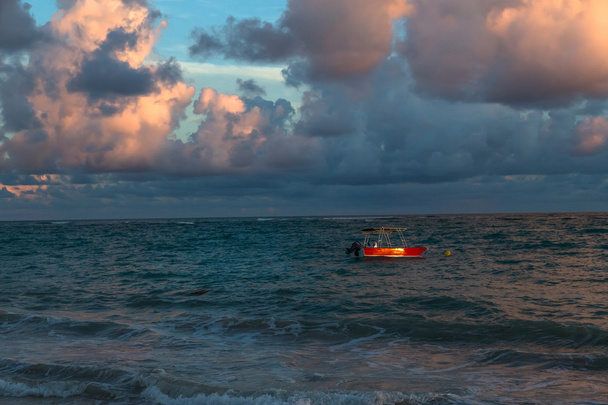 Красная лодка на красочных водах Атлантического океана, Доминиканская Республика
 - Фото, изображение