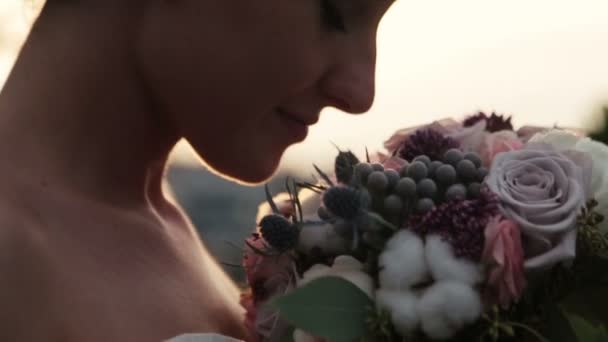 Happy charming brunette bride smiling with bouquet in hands close up - Imágenes, Vídeo