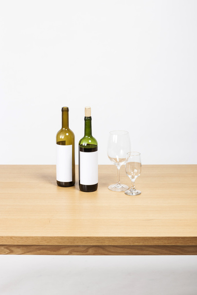 le bureau en bois (table) avec bouteille de vin et verres isolés blanc
. - Photo, image