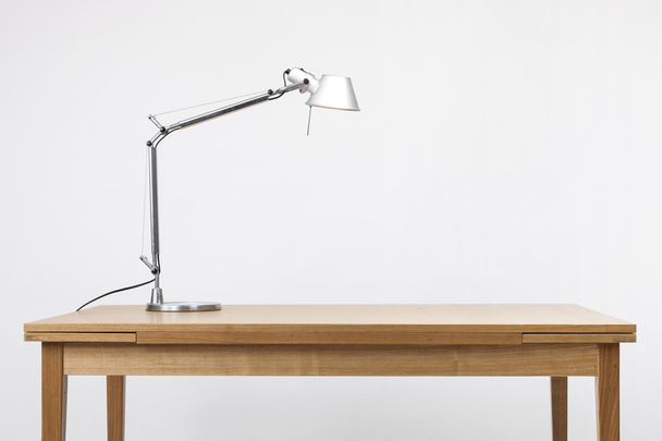 Un support d'éclairage en aluminium sur le bureau en bois (table) isolé blanc
. - Photo, image