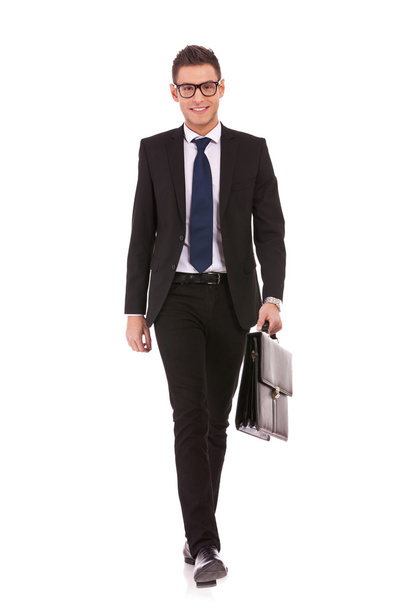 Jeune homme d'affaires portant une valise, marchant
 - Photo, image