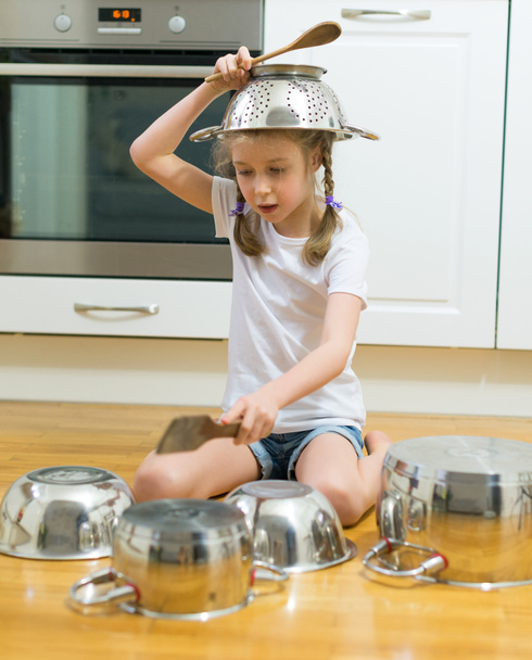 kleines Mädchen trommelt in der Küche auf Töpfen und Pfannen. - Foto, Bild