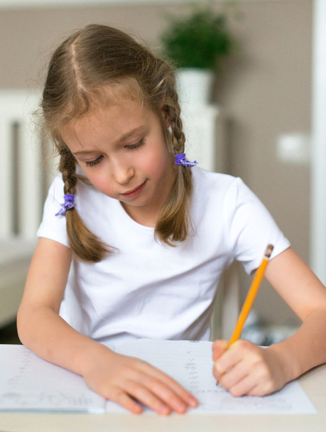 Cute little girl doing her homework for school. - Foto, afbeelding