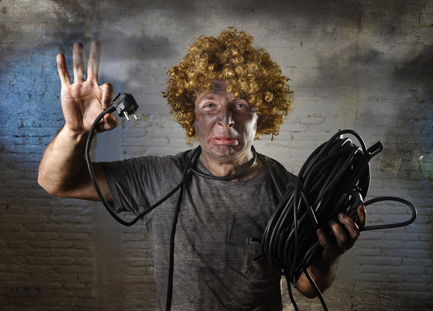 hombre con cable fumar después de accidente doméstico con la cara quemada sucia choque expresión electrocutada
  - Foto, Imagen