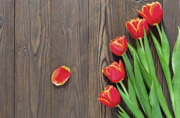 red tulips and kraft envelope on a wooden background - Фото, зображення