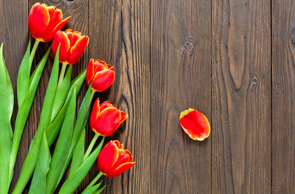 red tulips and kraft envelope on a wooden background - 写真・画像