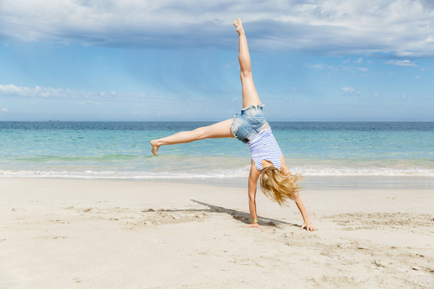 Young woman jumping on beach - Zdjęcie, obraz