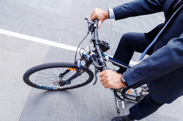 Successful businessman riding bicycle - Фото, изображение
