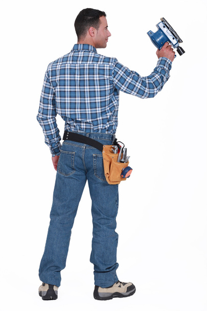 Rear view of a man with a sander - Фото, зображення