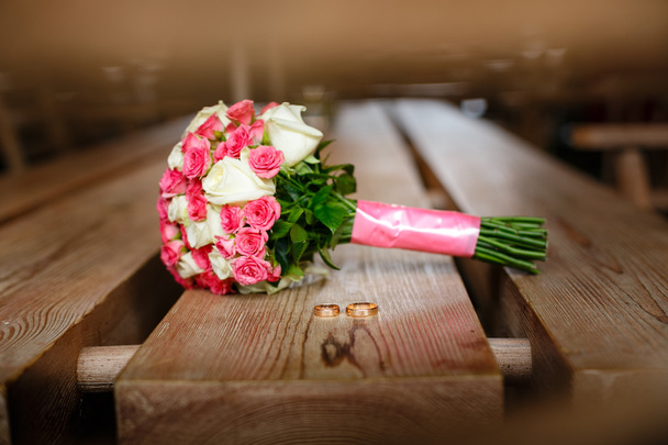 a imagem do buquê de casamento e dois anéis na mesa
 - Foto, Imagem