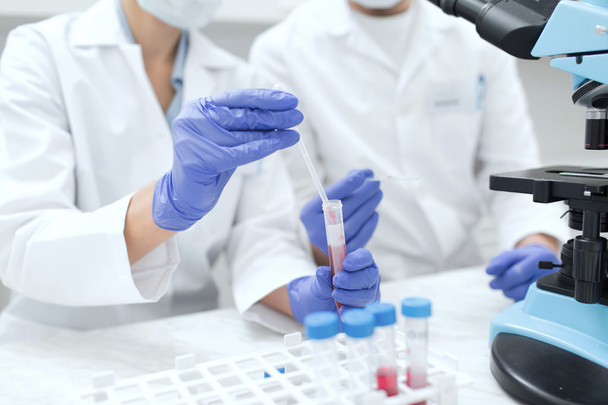 close up of scientists filling test tube in lab - Φωτογραφία, εικόνα