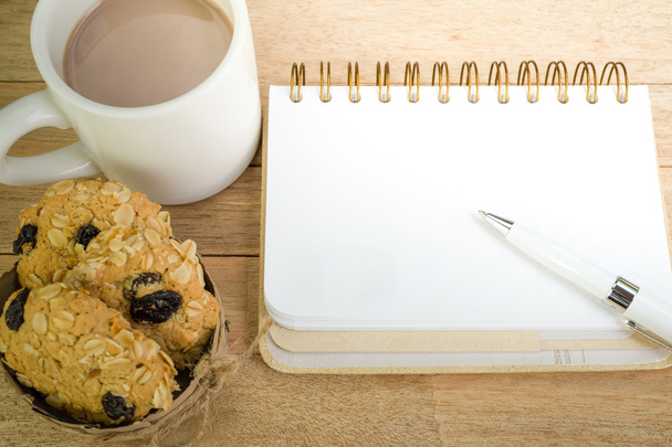 Чистый блокнот с кофе и овсяным печеньем на деревянном фоне
 - Фото, изображение